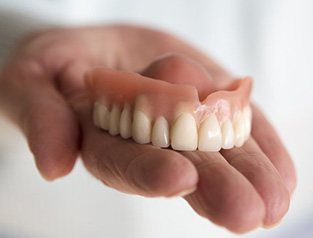 Upper denture in a person’s hand