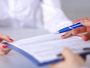 hands exchanging forms on a clipboard
