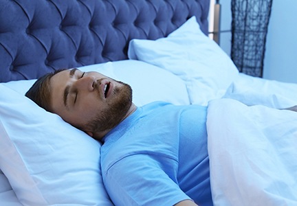 Man with sleep apnea in Greenfield snoring in bed