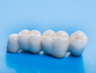 A dental bridge resting on a mat