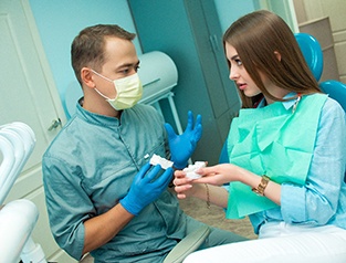 Greenfield dentist showing patient dental bridge options 
