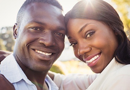 man and woman smiling with heads together