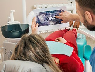 dentist showing patient in red x-rays