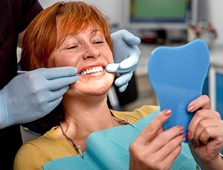 woman checking smile in mirror