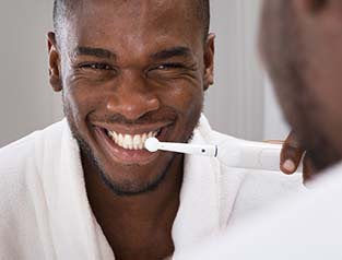 Man brushing teeth to prevent dental emergencies