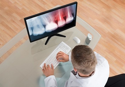 A dentist reviewing a patient’s X-ray.