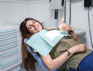 woman smiling giving thumbs up