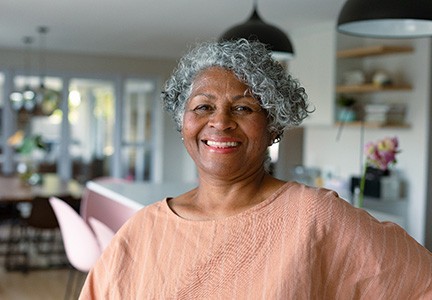 Senior woman smiling with implant dentures in Greenfield, WI
