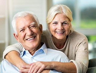 Senior couple smiling with implant dentures in Greenfield, WI