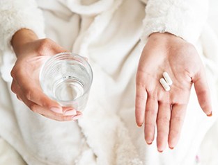 a person preparing to take medication pills