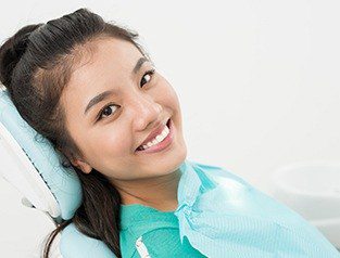 A woman smiling in a dental chair