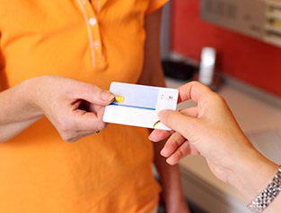 A patient handing a dental employee a credit card