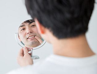 man checking smile in mirror