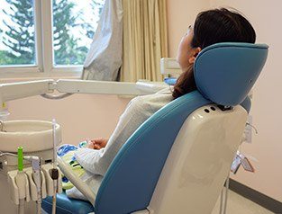 woman sedated in blue exam chair