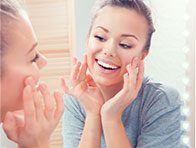 woman smiling into mirror