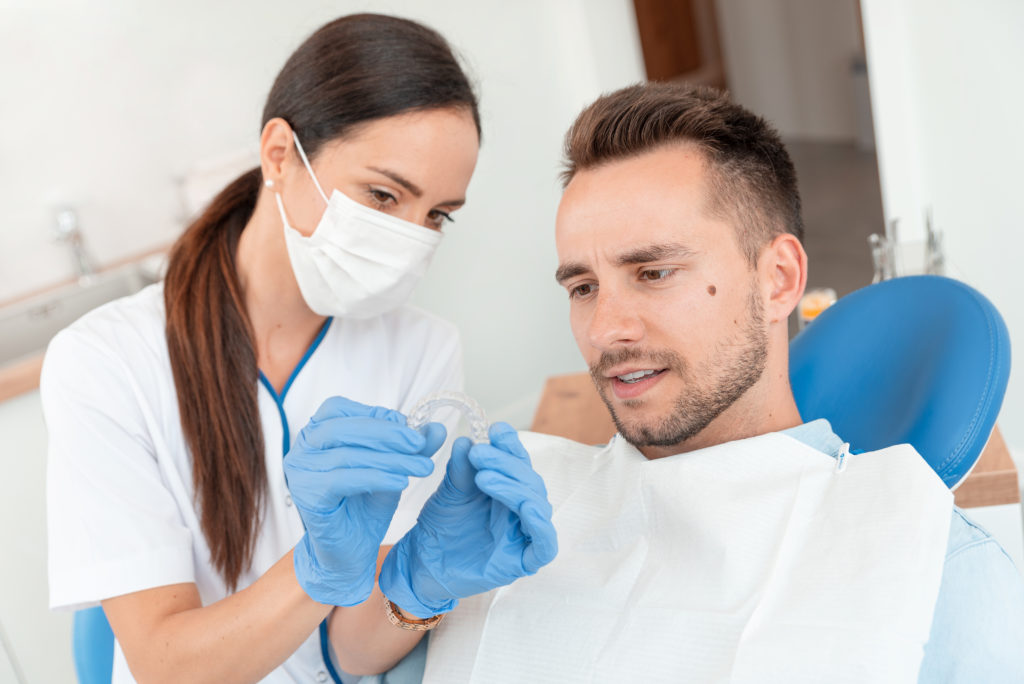 Dentist demonstrating Invisalign in Greenfield