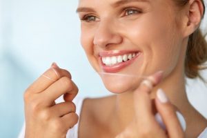 young woman flossing teeth