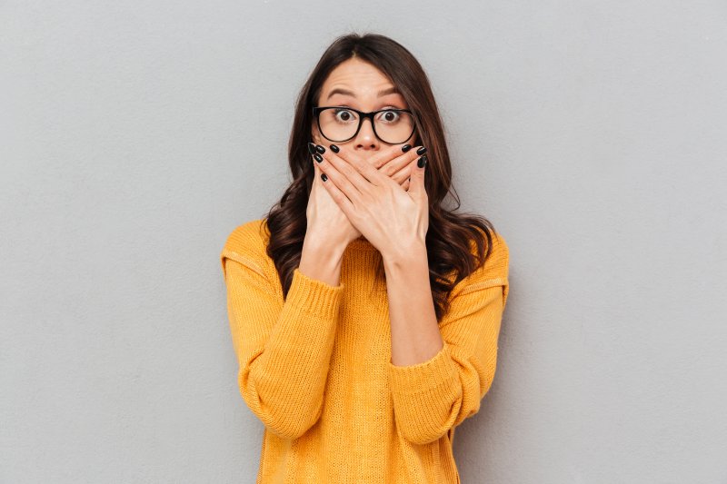 Embarrassed woman covering her mouth.