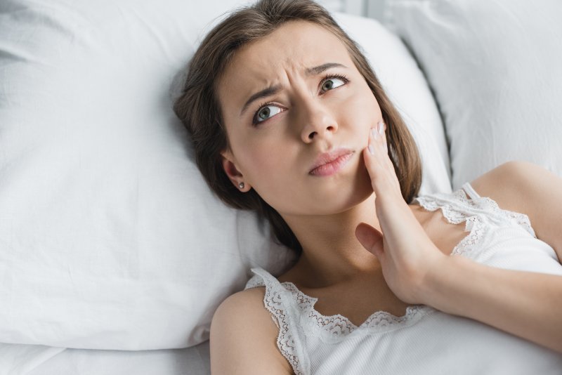 A woman with a toothache lying in bed
