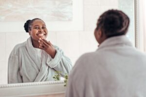 a person smiling while looking in the mirror