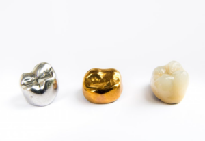 Three different dental crowns on a white surface