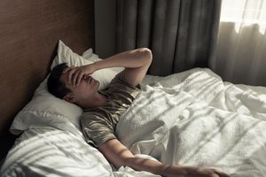 Tired man lying in bed 